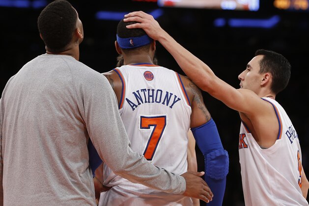 New York Knicks' Carmelo Anthony (7) is encouraged by teammates Jeremy Tyler, left, and Pablo Prigioni, of Argentina, at the end of an NBA basketball game against the Dallas Mavericks Monday, Feb. 24, 2014, in New York.  Dallas won 110-108. (AP Photo/Jason DeCrow)