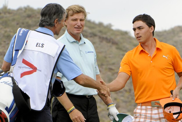 Feb 23, 2014; Marana, AZ, USA; Rickie Fowler shakes hands with caddy Colin Byrne after defeating Ernie Els (middle) on the19th hole of the 3rd place playoff match of the World Golf Championships - Accenture Match Play Championship at The Golf Club at Dove Mountain. Mandatory Credit: Casey Sapio-USA TODAY Sports