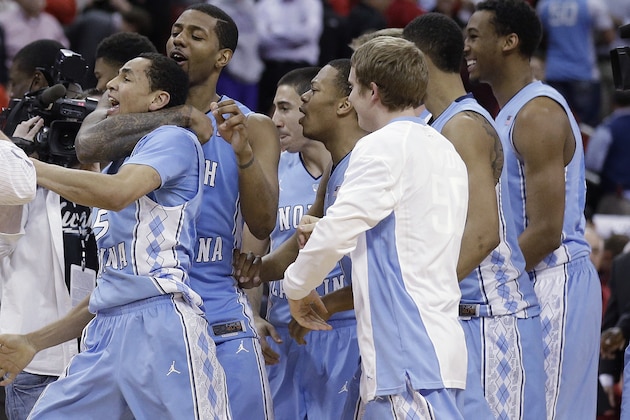 North Carolina's Leslie McDonald hugs Marcus Paige (5) as teammates celebrate Paige's shot in overtime following an NCAA college basketball game in Raleigh, N.C., Wednesday, Feb. 26, 2014. North Carolina defeated North Carolina State 85-84 in overtime. (AP Photo/Gerry Broome)