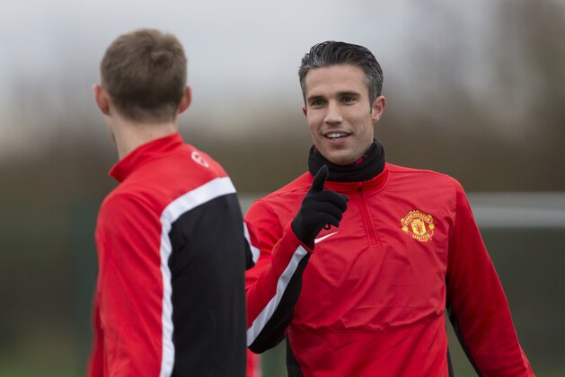 Manchester United's Robin van Persie, right, trains with teammates at Carrington training ground in Manchester, Monday, Feb. 24, 2014. Manchester United will play Olympiakos in a Champions League first knockout round on Tuesday. (AP Photo/Jon Super)
