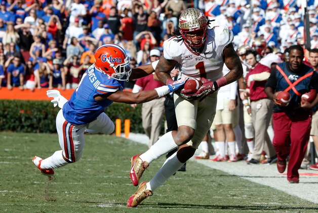 GAINESVILLE, FL - NOVEMBER 30:  Kelvin Benjamin #1 of the Florida State Seminoles runs past Vernon Hargreaves III #1 of the Florida Gators during the game on November 30, 2013 in Gainesville, Florida.  (Photo by Sam Greenwood/Getty Images)