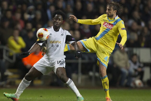 Swansea's Wilfried Bony, left, fights for the ball against Napoli's Henrique during their Europa League round of 32 first leg soccer match at the Liberty Stadium, Swansea, Wales, Thursday Feb. 20, 2014. (AP Photo/Jon Super)