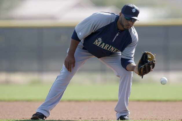 Seattle Mariners second baseman Robinson Cano (22) fields grounders during spring training baseball practice, Tuesday, Feb. 18, 2014, in Peoria, Ariz. (AP Photo/Rick Scuteri)