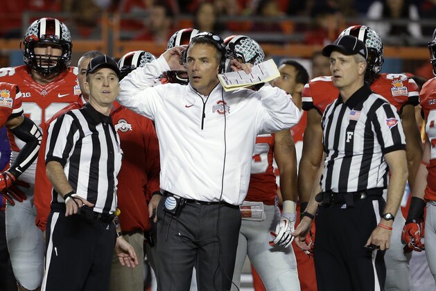 Ohio State coach Urban Meyer stands with officials as they wait for a ruling on the field during the first half of the Orange Bowl NCAA college football game against Clemson, Friday, Jan. 3, 2014, in Miami Gardens, Fla. (AP Photo/Lynne Sladky)