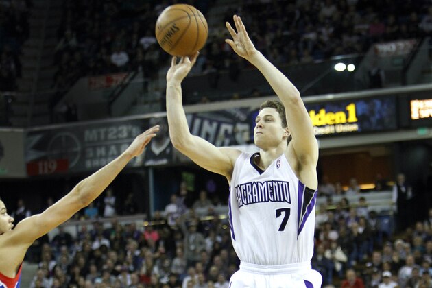 Sacramento Kings guard Jimmer Fredette (7) shoots over  Philadelphia 76ers defenders during the second half of an NBA basketball game in Sacramento, Calif., on Thursday, Jan. 2, 2014.(AP Photo/Steve Yeater)