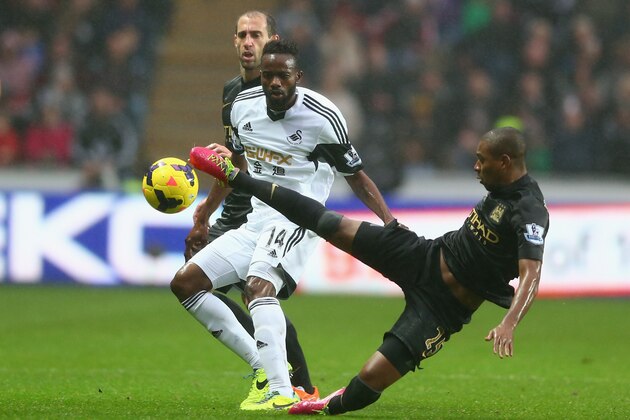 SWANSEA, WALES - JANUARY 01:  Roland Lamah (L) of Swansea City watches Fernandinho (R) of Manchester City during the Barclays Premier League match between Swansea City and Manchester City at the Liberty Stadium on January 1, 2014 in Swansea, Wales.  (Photo by Michael Steele/Getty Images)