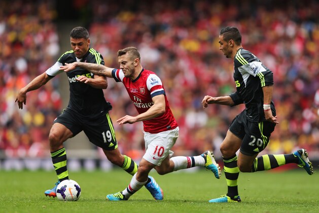 LONDON, ENGLAND - SEPTEMBER 22:  Jack Wilshere of Arsenal goes between Jonathan Walters (19) and Geoff Cameron of Stoke City (20) during the Barclays Premier League match between Arsenal and Stoke City at Emirates Stadium on September 22, 2013 in London, England.  (Photo by Ian Walton/Getty Images)