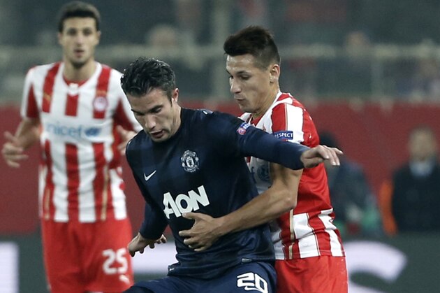 Olympiakos' Herman Perez, right, fights for the ball with Manchester United's Robin Van Persie during their Champions League, round of 16, first leg soccer match at Georgios Karaiskakis stadium, in Piraeus port, near Athens, on Tuesday, Feb. 25, 2014. (AP Photo/Petros Giannakouris)