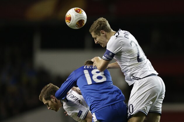 Tottenham's Michael Dawson, right, competes for the ball with Dnipro's Roman Zozulya, center, during the Europa League Group K soccer match between Tottenham Hotspur and Dnipro at White Hart Lane stadium in London, Thursday, Feb. 27, 2014.  (AP Photo/Matt Dunham)
