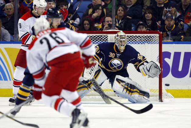 Feb 25, 2014; Buffalo, NY, USA; Buffalo Sabres goalie Ryan Miller (30) looks to make a save on Carolina Hurricanes defenseman John-Michael Liles (26) during the second period at First Niagara Center. Mandatory Credit: Timothy T. Ludwig-USA TODAY Sports