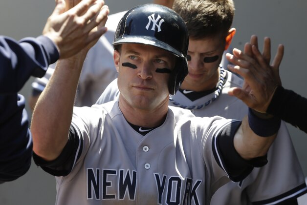 New York Yankees' Jayson Nix is greeted in the dugout after he scored in the second inning of a baseball game against the Seattle Mariners, Sunday, June 9, 2013, in Seattle. (AP Photo/Ted S. Warren)