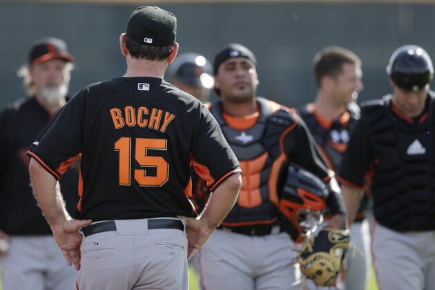 San Francisco Giants manager Bruce Bochy (15) looks on as a group of mostly catchers return during spring training baseball practice on Sunday, Feb. 16, 2014, in Scottsdale, Ariz. (AP Photo/Gregory Bull)