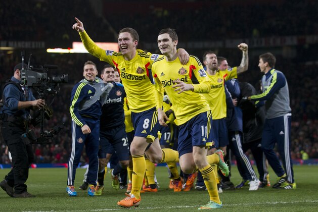 Sunderland's Craig Gardner, centre left, celebrates with teammate Adam Johnson after their team's penalty win against Manchester United during their English League Cup semifinal second leg soccer match at Old Trafford Stadium, Manchester, England, Wednesday Jan. 22, 2014. (AP Photo/Jon Super)