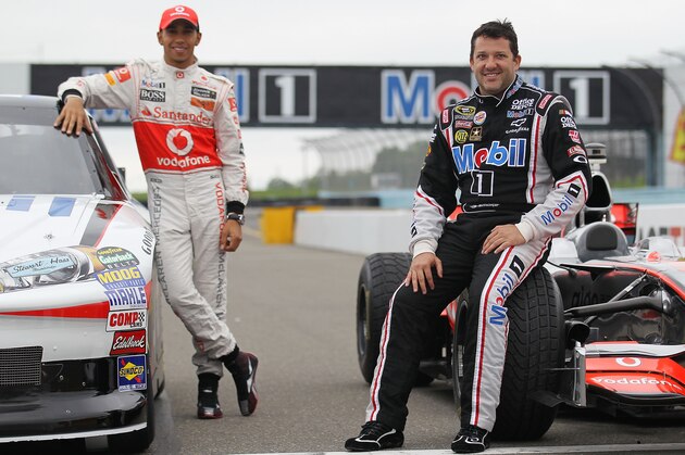 WATKINS GLEN, NY - JUNE 14:  (L-R) Lewis Hamilton of England, driver of the Vodafone McLaren Mercedes MP4-23 poses for photographers alongside Tony Stewart driver of the #14 Mobil 1/Office Depot Chevrolet during the Mobil 1 Car Swap at Watkins Glen International on June 14, 2011 in Watkins Glen, New York.  (Photo by Nick Laham/Getty Images for Mobil 1)