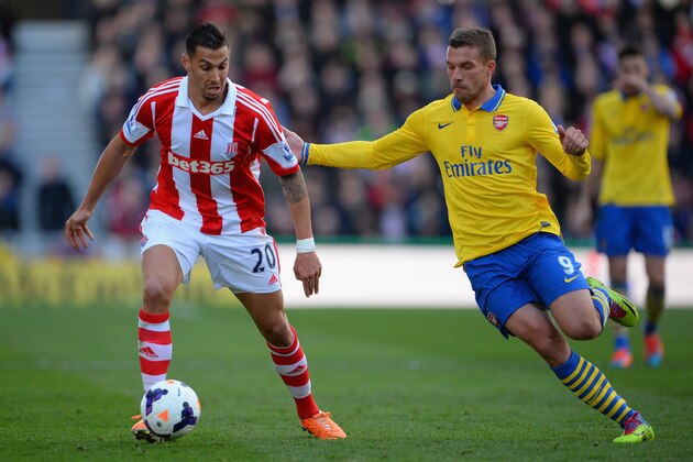 STOKE ON TRENT, ENGLAND - MARCH 01:  Lukas Podolski of Arsenal competes with Geoff Cameron of Stoke City during the Barclays Pemier League match between Stoke City and Arsenal at the Britannia Stadium on March 1, 2014 in Stoke on Trent, England.  (Photo by Michael Regan/Getty Images)