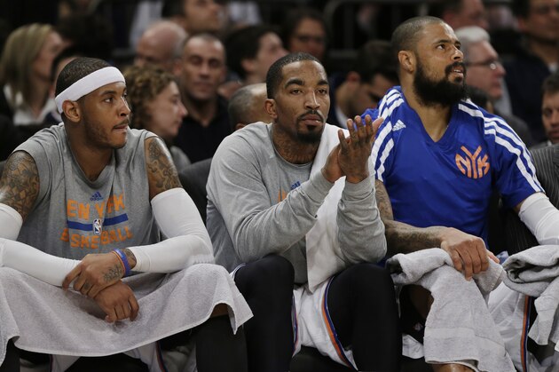 New York Knicks' Carmelo Anthony, left, J.R. Smith, center, and Tyson Chandler watch during the second half of an NBA basketball game against the Golden State Warriors, Friday, Feb. 28, 2014, in New York. The Warriors won the game 126-103. (AP Photo/Frank Franklin II)