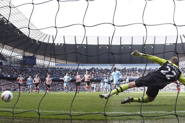 Manchester City's Mario Balotelli, centre, scores a penalty past Sunderland goalkeeper Simon Mignolet during their English Premier League soccer match at The Etihad Stadium, Manchester, England, Saturday, March 31, 2012. (AP Photo/Jon Super)
