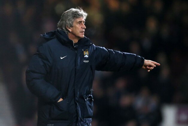 Manchester City's manager Manuel Pellegrini points towards his players during the second leg of the English League Cup semifinal soccer match between West Ham United and Manchester City at the Boleyn stadium in London, Tuesday, Jan 21  2014.(AP Photo/Alastair Grant)