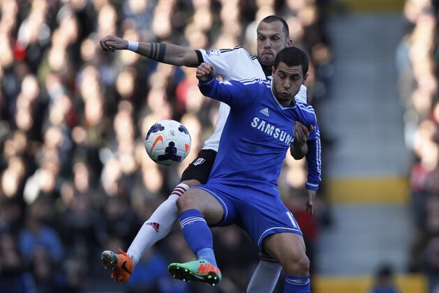 Fulham's John Heitinga, back, competes with Chelsea's Eden Hazard during their English Premier League soccer match at Craven Cottage, London, Saturday, March 1, 2014. (AP Photo/Sang Tan)
