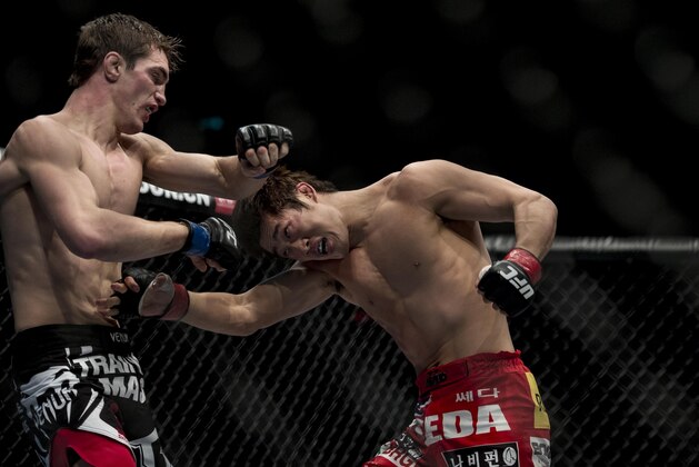 MACAU - MARCH 01:  Dong Hyun Kim (R) of South Korea and John Hathaway (L) of England fight in their welterweight bout during the UFC Fight Night at the Cotai Arena on March 1, 2014 in Macau, China.  (Photo by Victor Fraile/Getty Images)