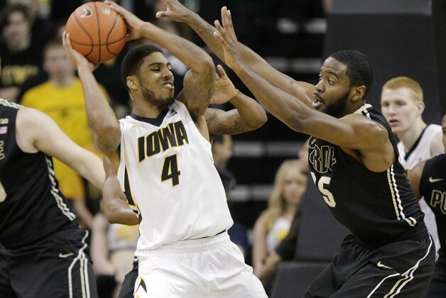 Iowa guard Roy Devyn Marble (4) is double-teamed by Purdue guard Rapheal Davis, right, and guard Ronnie Johnson, behind Marble, during the first half of a Big Ten NCAA college basketball game at Carver-Hawkeye Arena on Sunday, March 2, 2014, in Iowa City, Iowa. (AP Photo/Jim Slosiarek)