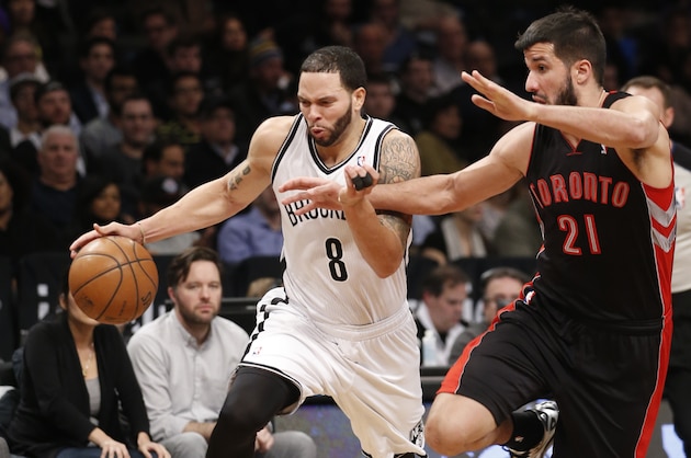 Brooklyn Nets guard Deron Williams (8) drives around Toronto Raptors guard Greivis Vasquez (21) in the first half of their NBA basketball game at the Barclays Center, Monday, Jan. 27, 2014, in New York. (AP Photo/Kathy Willens)