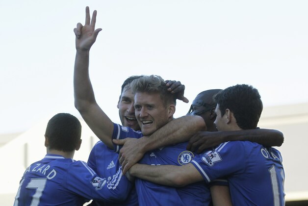 Chelsea's Andre Schurrle, center, celebrates his third goal against Fulham with teammates during their English Premier League soccer match at Craven Cottage, London, Saturday, March 1, 2014. (AP Photo/Sang Tan)