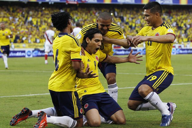 Colombia's Falcao Garcia, center, celebrates with teammates after scoring against Peru during a 2014 World Cup qualifying soccer match in Barranquilla, Colombia, Tuesday, June 11, 2013. At left is Juan Cuadrado, at center is Macnelly Torres, and at right is Teofilo Gutierrez. (AP Photo/Fernando Vergara)