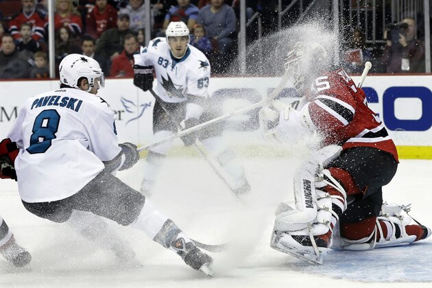 San Jose Sharks' Joe Pavelski (8) throws up ice as he shoots against New Jersey Devils goalie Cory Schneider (35) during the first period of an NHL hockey game on Sunday, March. 2, 2014, in Newark, N.J. (AP Photo/Mel Evans)