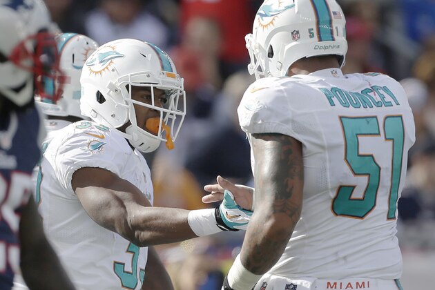 Miami Dolphins running back Daniel Thomas, left, celebrates his touchdown with center Mike Pouncey (51) in the second quarter of an NFL football game against the New England Patriots on Sunday, Oct. 27, 2013, in Foxborough, Mass. (AP Photo/Steven Senne)