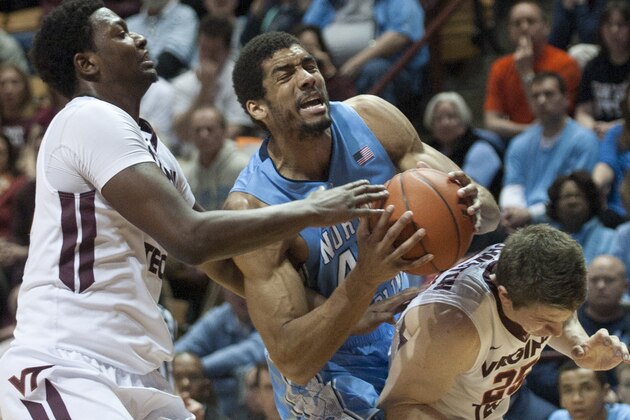 North Carolina's  James McAdoo, center, grabs a rebound against Virginia Tech's C.J. Barksdale, left, and Will Johnston during the second half of an NCAA college basketball game, Saturday, March 1, 2014, in Blacksburg, Va. North Carolina won 60-56. (AP Photo/Don Petersen)