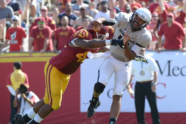 LOS ANGELES, CA - SEPTEMBER 21:  Chuckie Keeton #16 of the Utah State Aggies reacts as he is hit by Devon Kennard #42 of the USC Trojans at the Los Angeles Memorial Coliseum on September 21, 2013 in Los Angeles, California.  (Photo by Harry How/Getty Images)