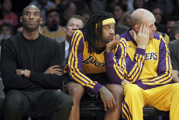 Los Angeles Lakers injured guard Kobe Bryant, left, center Jordan Hill, second from left, center Chris Kaman and guard Jordan Farmar, right, sit on the bench during the Milwaukee Bucks' 94-79 win in an NBA basketball game Tuesday, Dec. 31, 2013, in Los Angeles. (AP Photo/Alex Gallardo)