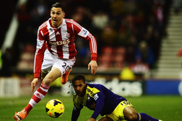 STOKE ON TRENT, ENGLAND - FEBRUARY 12:  Geoff Cameron (L) of Stoke City is challenged by Wayne Routledge (R) of Swansea City during the Barclays Premier League match between Stoke City and Swansea City at the Britannia Stadium on February 12, 2014 in Stoke on Trent, England.  (Photo by Jamie McDonald/Getty Images)