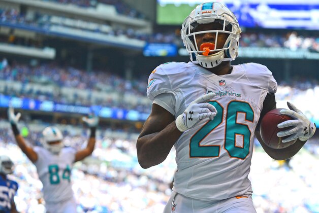 Sep 15, 2013; Indianapolis, IN, USA; Miami Dolphins running back Lamar Miller (26) scores a touchdown during the first quarter against the Indianapolis Colts at Lucas Oil Stadium. Mandatory Credit: Andrew Weber-USA TODAY Sports