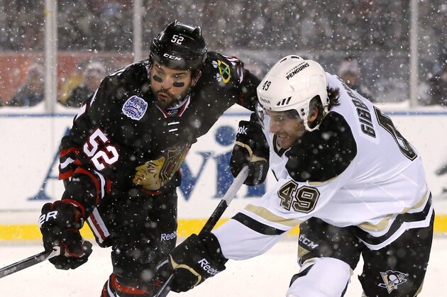 Pittsburgh Penguins center Brian Gibbons (49) has his shot deflected by Chicago Blackhawks left wing Brandon Bollig during the first period of an NHL Stadium Series hockey game at Soldier Field on Saturday, March 1, 2014, in Chicago. (AP Photo/Charles Rex Arbogast)