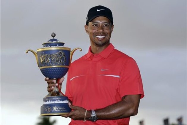 Tiger Woods holds the Gene Sarazen Cup for winning the Cadillac Championship golf tournament on Sunday, March 10, 2013, in Doral, Fla.  (AP Photo/Wilfredo Lee)