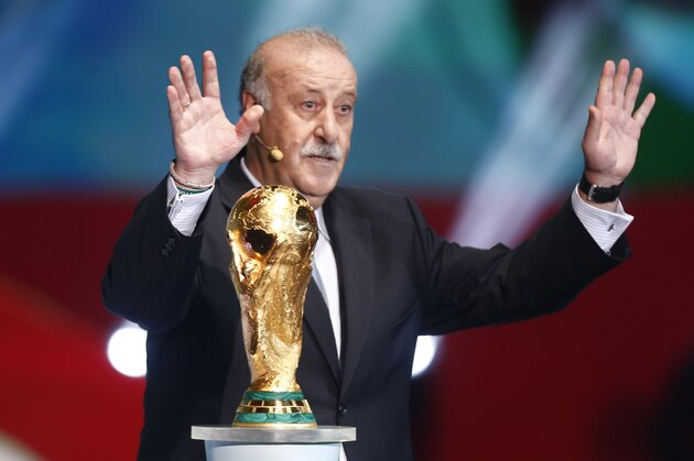 Spain head coach Vicente Del Bosque brings the World Cup trophy onto the stage during the draw ceremony for the 2014 soccer World Cup in Costa do Sauipe near Salvador, Brazil, Friday, Dec. 6, 2013. (AP Photo/Victor R. Caivano)