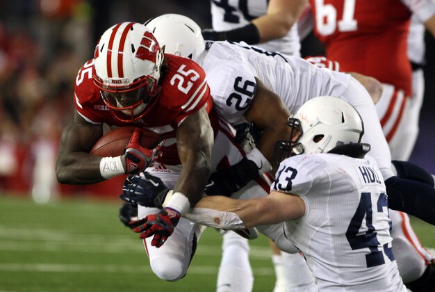 Nov 30, 2013; Madison, WI, USA; Wisconsin Badgers running back Melvin Gordon (25) rushes for a first down as Penn State Nittany Lions linebacker Brandon Bell (26) and Mike Hull (43) make the stop at Camp Randall Stadium. Penn State defeated Wisconsin 31-24. Mandatory Credit: Mary Langenfeld-USA TODAY Sports