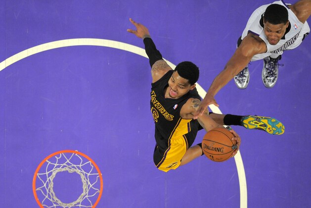 Los Angeles Lakers guard Kent Bazemore, left, goes up for a dunk as Sacramento Kings forward Rudy Gay defends during the first half of an NBA basketball game, Friday, Feb. 28, 2014, in Los Angeles. (AP Photo/Mark J. Terrill)