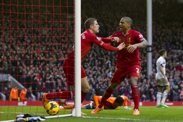 Liverpool's Jordan Henderson, centre, celebrates with teammate Glen Johnson after scoring past Swansea City goalkeeper Michel Vorm, bottom, during their English Premier League soccer match at Anfield Stadium, Liverpool, England, Sunday Feb. 23, 2014. (AP Photo/Jon Super)