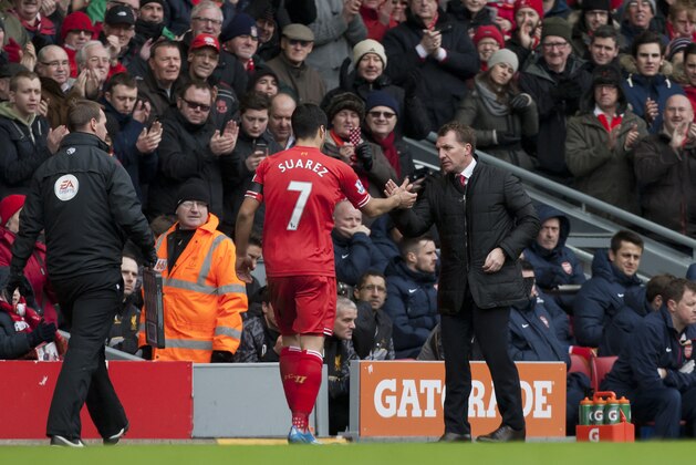 Liverpool's Luis Suarez, centre, shakes hands with manager Brendan Rodgers after being substituted during his team's English Premier League soccer match against Arsenal at Anfield Stadium, Liverpool, England, Saturday Feb. 8, 2014. (AP Photo/Jon Super)