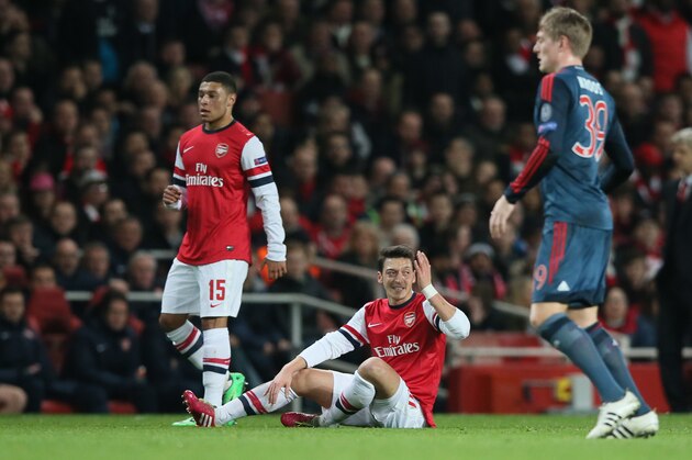 Arsenal's Mesut Ozil, on the ground, gestures after missing a pass during a Champions League, round of 16, first leg soccer match between Arsenal and Bayern Munich at the Emirates stadium in London, Wednesday, Feb. 19, 2014. (AP Photo/Alastair Grant)