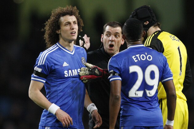 Chelsea's David Luiz, left, is shown a yellow card by referee Phil Dowd, second left during their English FA Cup fifth round soccer match against Manchester City at the Etihad Stadium, Manchester, England, Saturday, Feb. 15, 2014. (AP Photo/Jon Super)