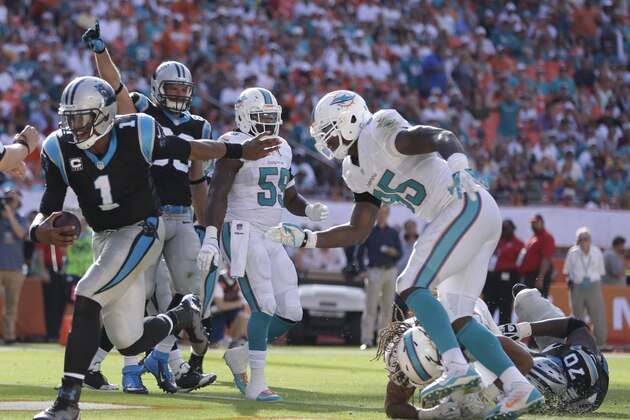 Carolina Panthers quarterback Cam Newton (1) avoids a tackle buy Miami Dolphins defensive end Dion Jordan (95) to score a touchdown during the second half of an NFL football game, Sunday, Nov. 24, 2013, in Miami Gardens, Fla. (AP Photo/Lynne Sladky)