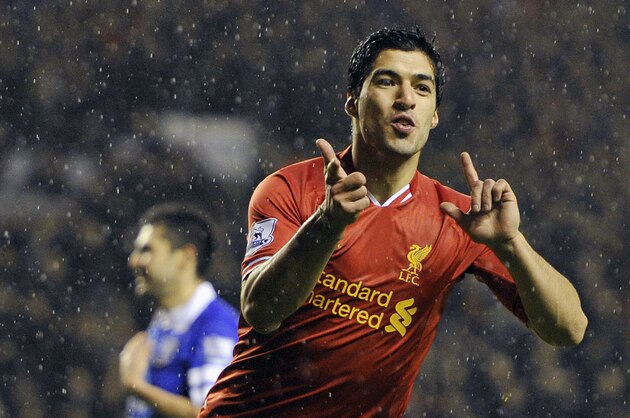 Liverpool's Luis Suarez celebrates after he scores the fourth goal of the game for his side during their English Premier League soccer match against Everton at Anfield in Liverpool, England, Tuesday Jan. 28, 2014. (AP Photo/Clint Hughes)