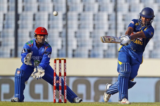 Sri Lanka’s Kumar Sangakkara, right, plays a shot as Afghanistan's Mohammad Shahzad watches during their Asia Cup one-day international cricket tournament in Dhaka, Bangladesh, Monday, March 3, 2014. (AP Photo/A.M. Ahad)