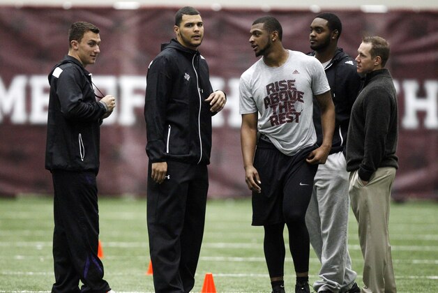 Texas A&M quarterback Johnny Manziel, from left, and receiver Mike Evans talk with linebacker Nate Askew as he prepares to compete in Texas A&M's pro day held Wednesday, March 5, 2014, in College Station, Texas. Manziel and Evans did not compete in the event. (AP Photo/Patric Schneider)