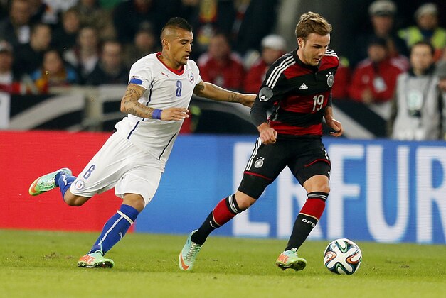 Germany's Mario Goetze, right, and Chile's Arturo Vidal challenge for the ball during a soccer friendly match between Germany and Chile in Stuttgart, Germany, Wednesday, March 5, 2014. (AP Photo/Michael Probst)
