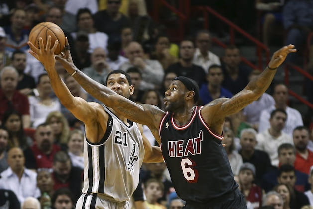 Miami Heat's LeBron James (6) fouls San Antonio Spurs' Tim Duncan (21) as he tries to steal the ball during the second half of an NBA basketball game in Miami, Sunday, Jan. 26, 2014. The Heat won 113-101. (AP Photo/J Pat Carter)